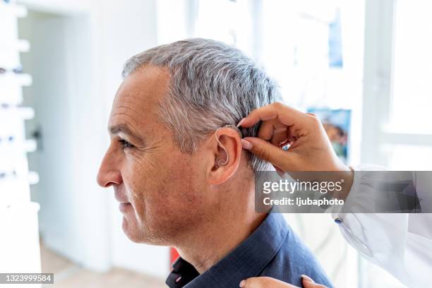 nurse and patient with hearing aid - human ear stockfoto's en -beelden