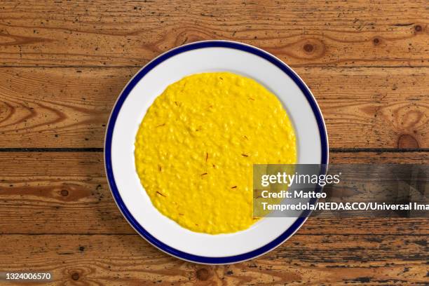 yellow saffron risotto with chicken broth and overcooked leeks - milanese stockfoto's en -beelden