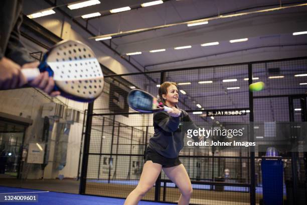 woman playing padel at indoor court - paddle tennis foto e immagini stock