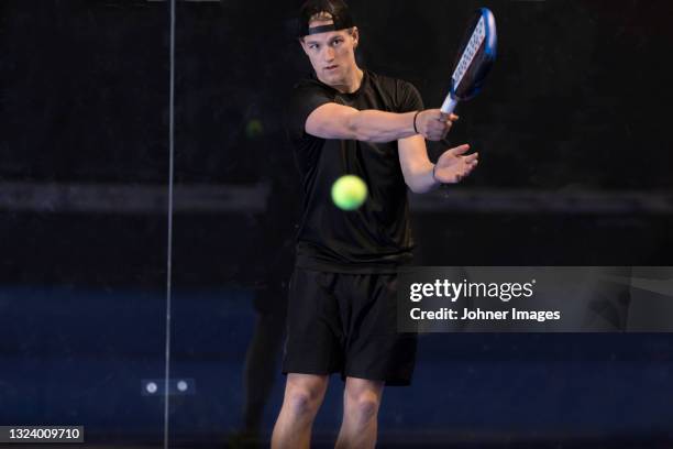 man playing padel at indoor court - pudel stock pictures, royalty-free photos & images