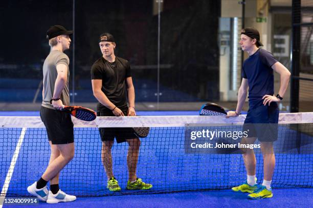 men talking at indoor padel court - using a paddle imagens e fotografias de stock