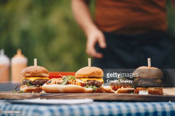 hot dogs und hamburger auf hackbrett gelegt. - hotdog stock-fotos und bilder
