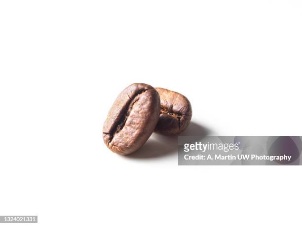 aromatic roasted coffe beans on white background - roasted coffee bean stock pictures, royalty-free photos & images