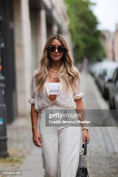 Janina Pfau wearing white crop top, beige shirt and pants and Dior saddle bag on June 15, 2021 in Berlin, Germany.