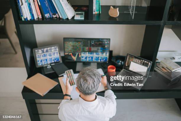 vista trasera de alto ángulo vista trasera hombre chino senior con rastrojos de cabello trabajando en casa con el mercado de valores monitor de computadora múltiple monitoreo de la tendencia del mercado - working behind laptop fotografías e imágenes de stock