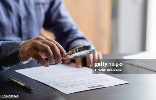 businessman signing legal paper in office - magnifying glass 個照片及圖片檔