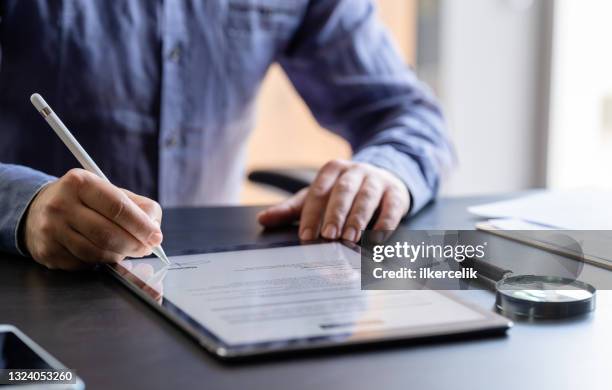 man signing the digital contract - digital tablet imagens e fotografias de stock