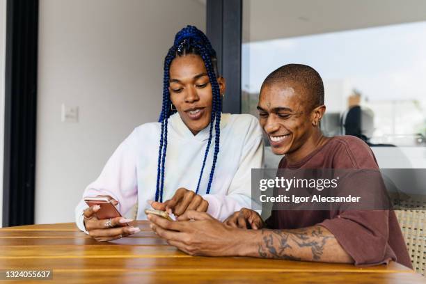 trans woman and non-binary person choosing food in the app - 非二元性別 個照片及圖片檔