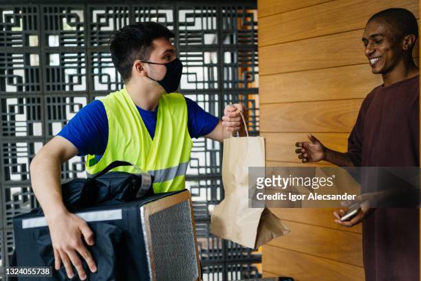 motoboy delivering an order to the customer - motoboy stock pictures, royalty-free photos & images