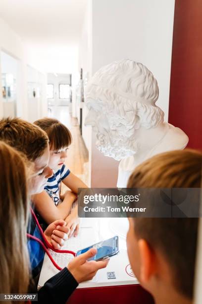 group of kids looking at marble bust while on field trip - bust museum imagens e fotografias de stock