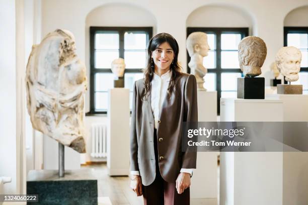 portrait of school teacher standing amidst classical sculptures in museum - guide touristique photos et images de collection