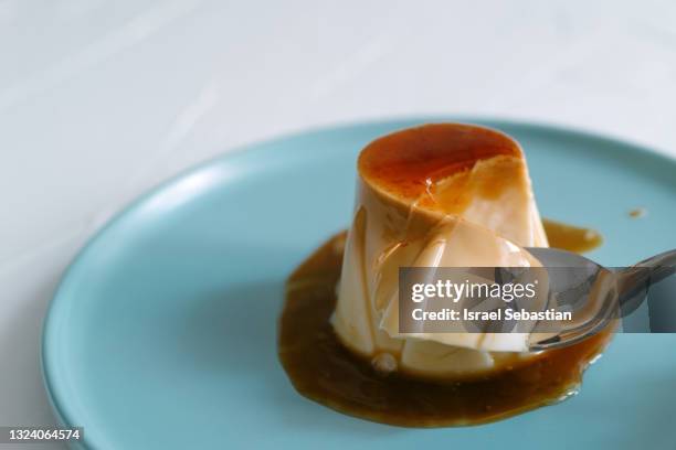 close up view of an unrecognizable person with a spoon with cheese flan ready to eat. - caramel stock pictures, royalty-free photos & images