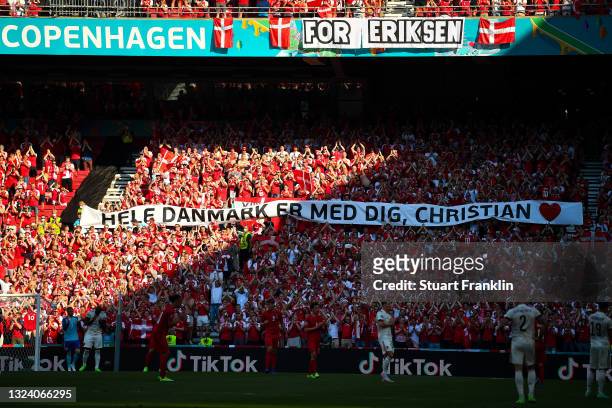 Banner of support is raised as the ball is kicked out of play in the tenth minute followed by a minute of applause in support of Denmark...