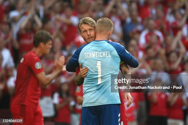 Simon Kjaer and Kasper Schmeichel of Denmark interact as the ball is kicked out of play in the tenth minute followed by a minute of applause in...
