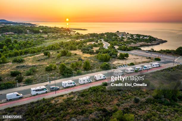 autocaravana rv y autocaravana están aparcados junto a la playa al amanecer - costa dorada fotografías e imágenes de stock