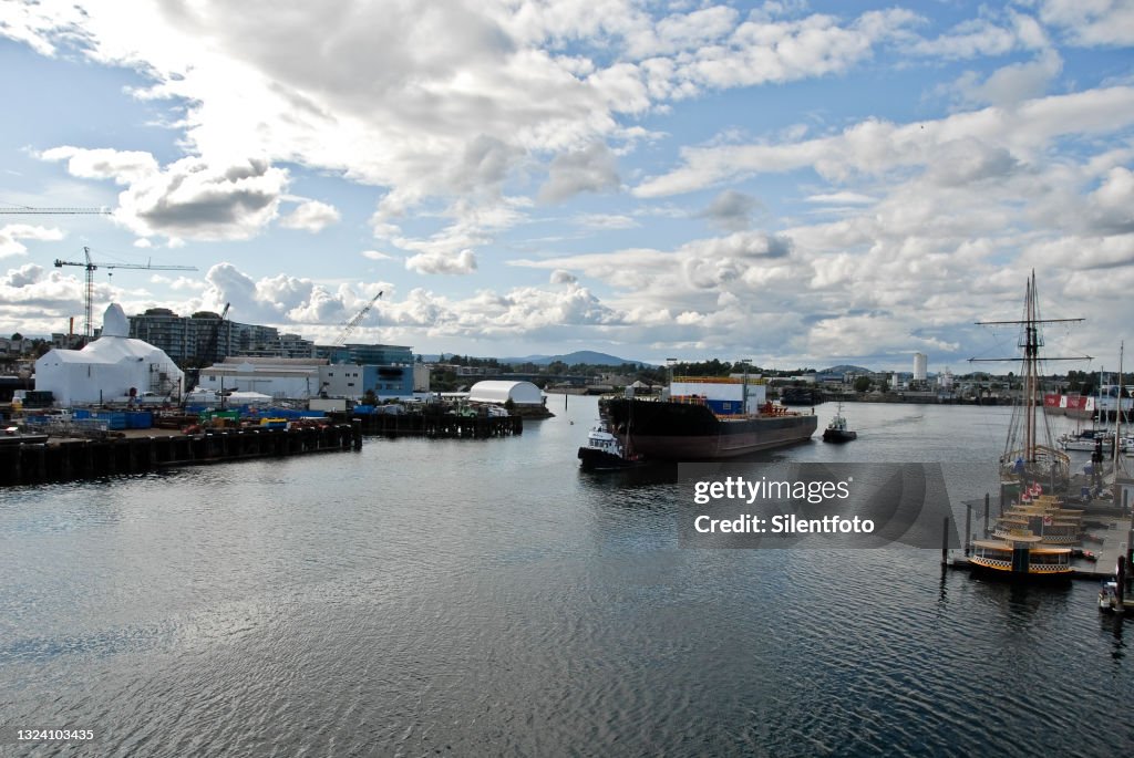 Tugboats Guiding Barge Through Waterway