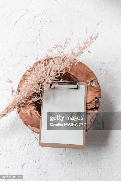 top view, flat lay blank template clipboard on teak wood bowl with bundle golden wild oat (avena fatua). - avena fatua stock pictures, royalty-free photos & images