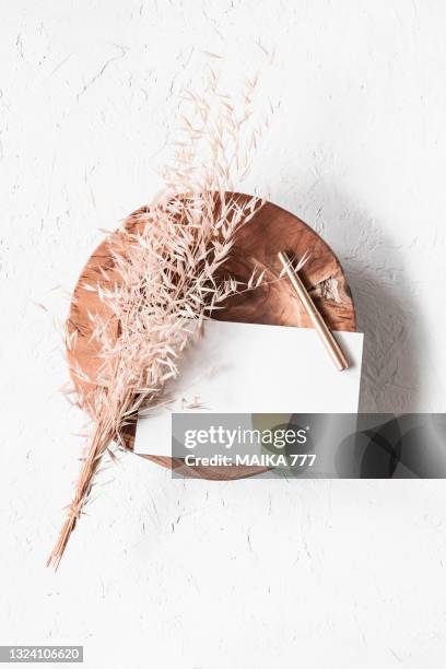 top view, flat lay blank template of a paper card and gold pencil on teak wood bowl with bundle golden wild oat (avena fatua). concept of greeting card for mothers day, wedding, happy event or birthday. - avena fatua stock pictures, royalty-free photos & images