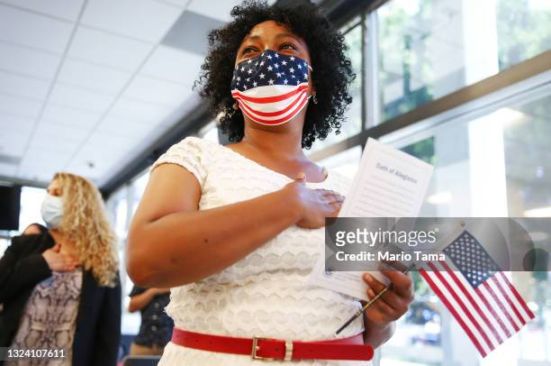 New U.S. Citizens including Selamawit Berhane , originally from Ethiopia, hold their hands over their hearts during a special World Refugee Day...