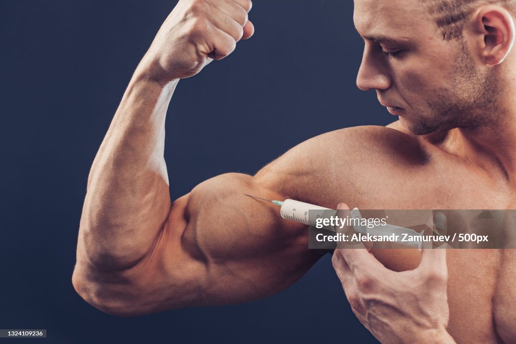 A muscular man with a syringe