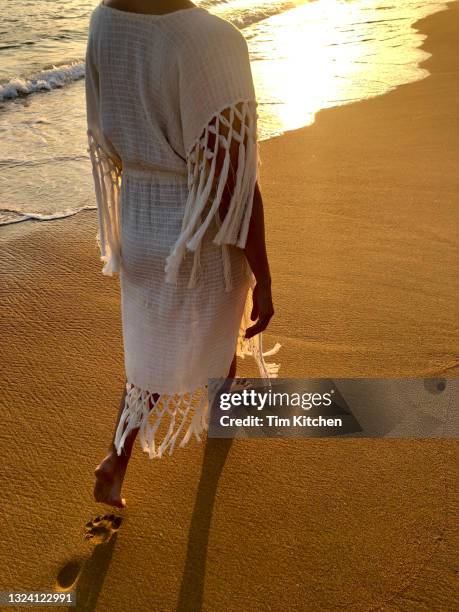 woman walks on the beach at sunset in san agustinillo, oaxaca, mexico - fringe dress stock-fotos und bilder