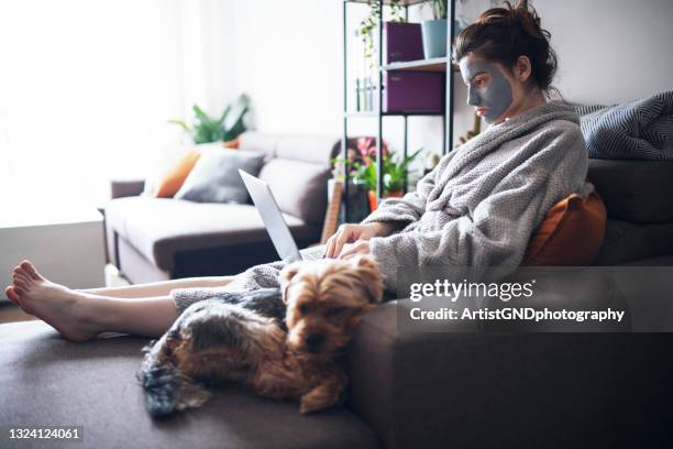 young woman at home using laptop. - robe stock pictures, royalty-free photos & images