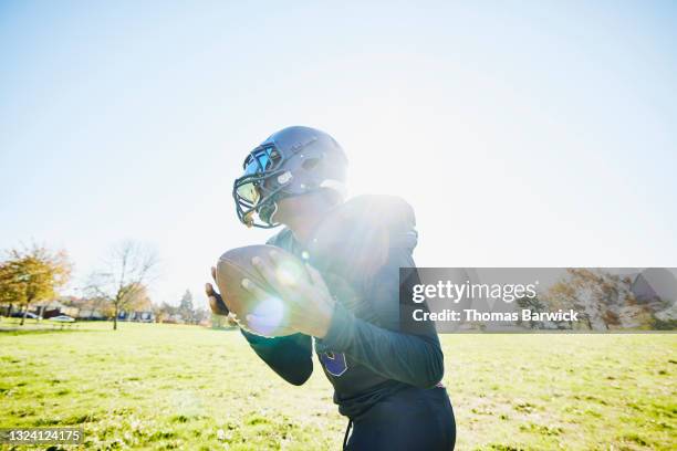 medium shot of young football player catching pass during practice on fall afternoon - safety american football player stockfoto's en -beelden