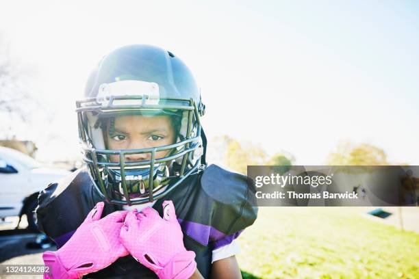 medium close up portrait of boy in football gear ready for game on fall afternoon - safety american football player stockfoto's en -beelden