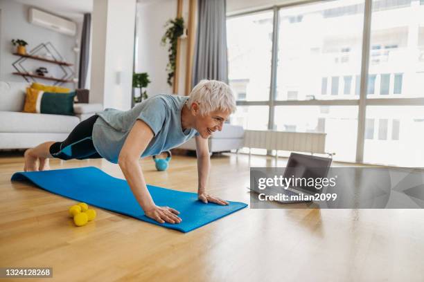 mujer mayor haciendo ejercicio - flexiones fotografías e imágenes de stock