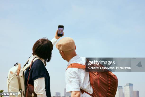 senior taking selfies - femme de dos smartphone photos et images de collection