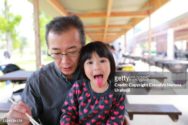 child showing her red tounge due to shaved ice strawberry flavor father and child quality time - かき氷 ストックフォトと画像