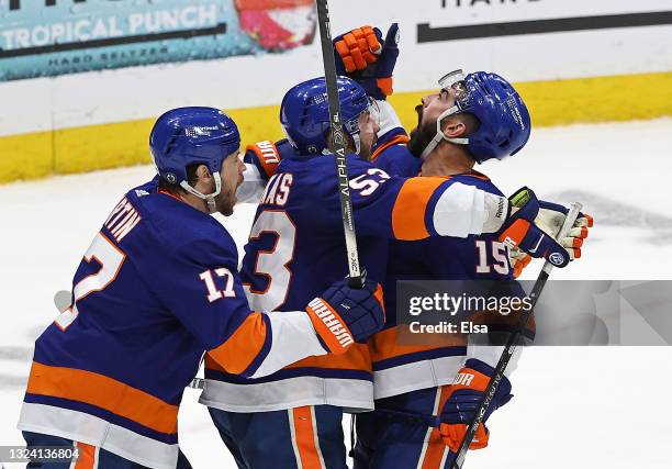 Cal Clutterbuck of the New York Islanders is congratulated by Casey Cizikas and Matt Martin after scoring a goal against the Tampa Bay Lightning...