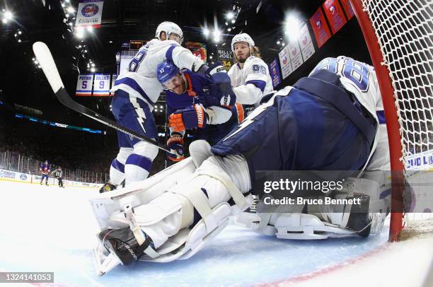 David Savard, Mikhail Sergachev and Andrei Vasilevskiy of the Tampa Bay Lightning defend against Casey Cizikas of the New York Islanders in Game...