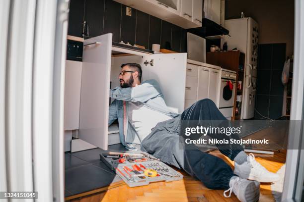 positive plumber at work - under sink stock pictures, royalty-free photos & images