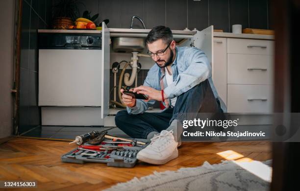 der klempner benutzt das telefon - verstopfung stock-fotos und bilder