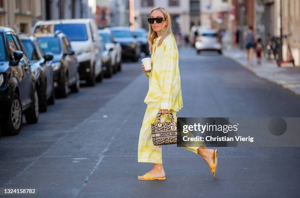 Sonia Lyson is seen wearing yellow Hermes sandals, Dior bag, Louis Vuitton sunglasses, yellow pyjama pants and button shirt on June 17, 2021 in...