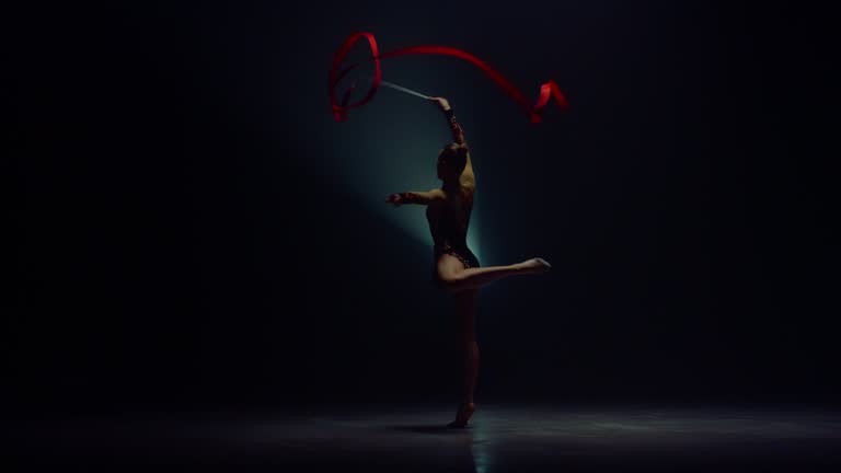 Spining Ribbon Flexible sportswoman spinning ribbon. Gymnast practicing rhythmic ...