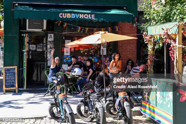 Customers pose and make hand gestures outside Cubbyhole, a well known lesbian & gay bar, in the West Village on June 17, 2021 in New York City. On...