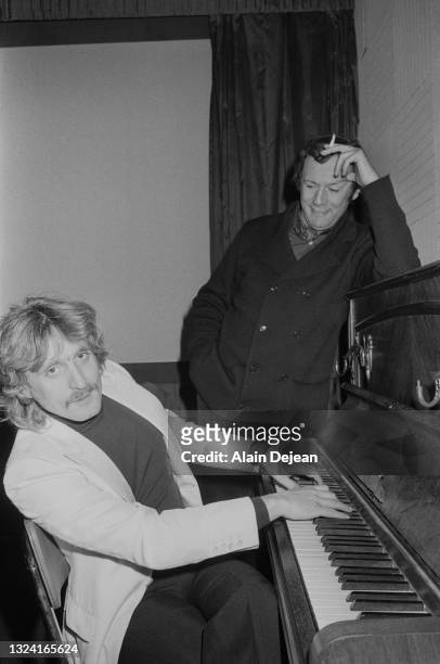 Le chanteur français Christophe au piano à côté de l'acteur britannique Richard Burton, une des vedettes du film « Jackpot », film pour lequel...
