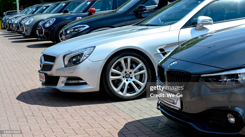 Eine Reihe moderner BMW Fahrzeuge und ein silberner Mercedes SL