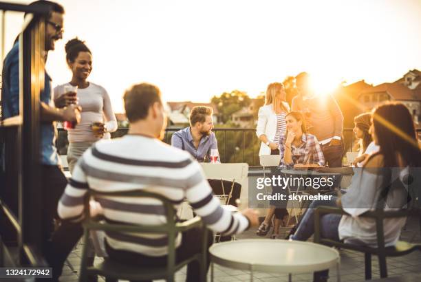 glückliche geschäftsleute, die nach der arbeit bei sonnenuntergang spaßig auf einem balkon haben. - businessman after work stock-fotos und bilder