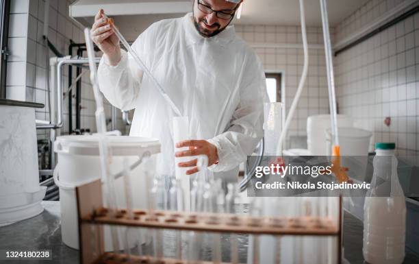 a technologist checks the milk - food and drink industry stockfoto's en -beelden