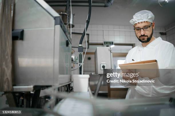 technologen-experte nimmt parameter aus industriemaschine in einer milchfabrik - food safety stock-fotos und bilder