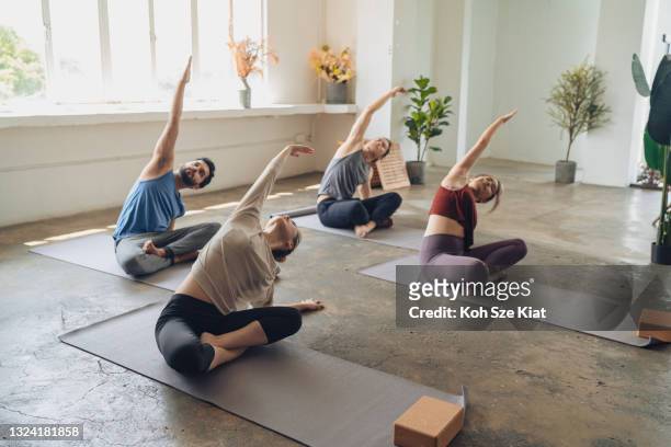 asian yoga students observing and practicing during class - yoga stock pictures, royalty-free photos & images