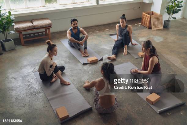 Members of a yoga class having a conversation after practice