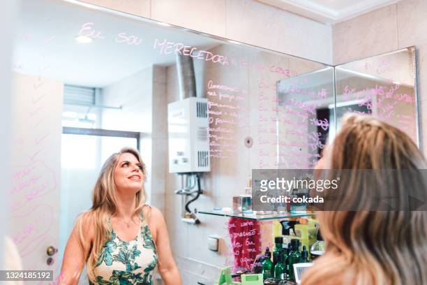 woman looking at motivational quotes on the mirror - health motivational quotes stock pictures, royalty-free photos & images