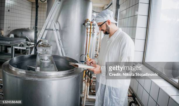 trabajador lechero escribe notas - refinería de azúcar fotografías e imágenes de stock