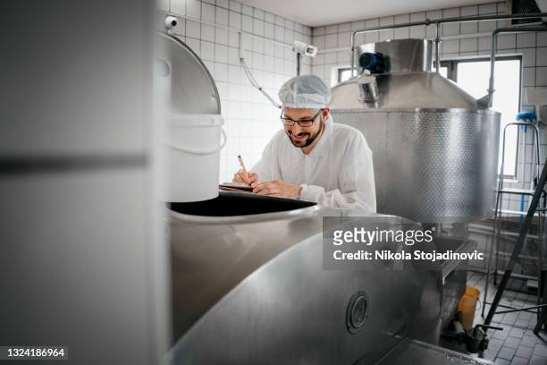dairy factory expert making notes - making cheese stock pictures, royalty-free photos & images