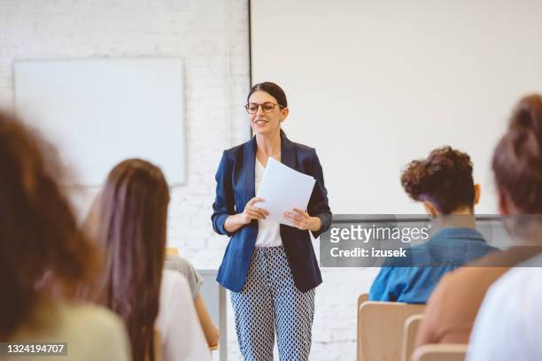 female teacher explaining students in classroom - university lecturer stock pictures, royalty-free photos & images