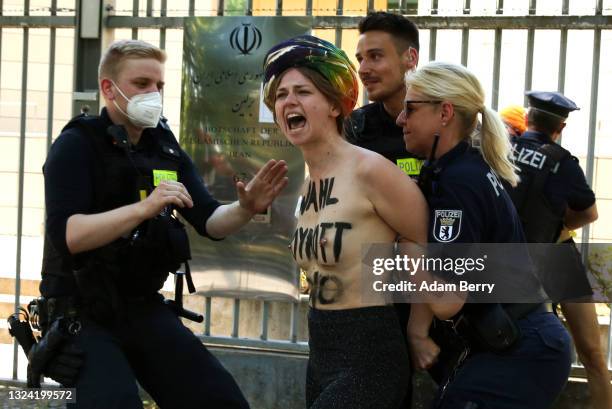 Activists from the group Femen are arrested by police officers in front of the Iranian embassy as they demonstrate against presidential elections...